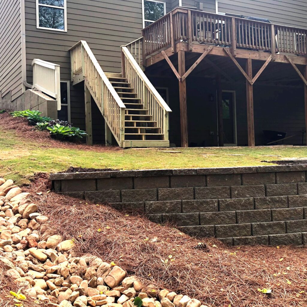landscape-drainage-solutions-atlanta-retaining-walls-dry-creek-bed Landscape drainage solutions in Atlanta include strategically placed retaining walls, native vegetation and Dry Creek beds