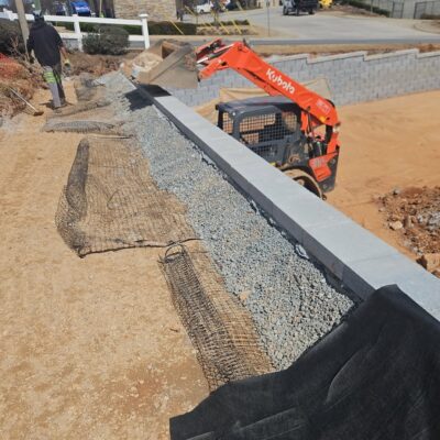 Essential landscape drainage behind new dunwoody concrete block retaining wall