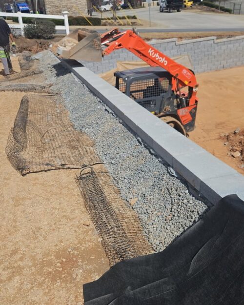 The Ricks Group retaining wall contractor Alpharetta GA install professional drainage requirements behind walls with fabric and gravel