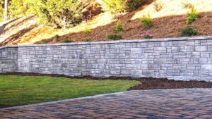 Beautiful Roswell GA hardscape retaining wall and driveway pavers with landscaping by the Ricks Group